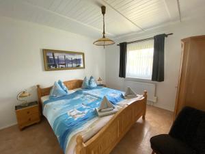 a bedroom with a large bed with blue sheets at Ferienhaus Schmidt in Storkow