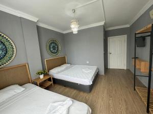 1 dormitorio con 2 camas y TV en la pared en GÜLER BUTİK HOTEL, en Antalya