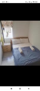 a bedroom with a blue bed with two pillows on it at Hogar calido calafell in Calafell