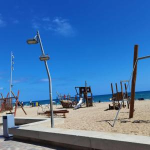 a street light on a beach with a playground at Hogar calido calafell in Calafell