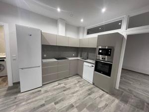 a kitchen with white appliances and a wooden floor at Living Colors Logroño GARAJE Aire wifi by Apartamentos Logrono in Logroño