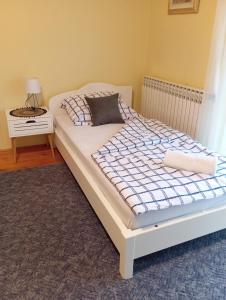 a bed in a room with a white bed frame at Apartman Rendulić in Ogulin