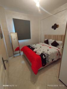 a bedroom with a bed with a red blanket at Magnifique appartement au RDC in Casablanca