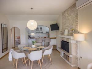 a living room with a table and chairs and a kitchen at Pebble Bay Paradise House in Vela Luka