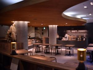 a restaurant with wooden tables and chairs and a counter at WeBase KAMAKURA in Kamakura