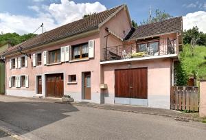 a pink house on the side of a street at Vert Olive - Maison proche Sélestat Colmar in Rombach-le-Franc