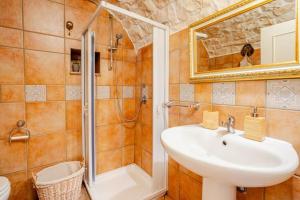 a bathroom with a sink and a shower at Trullo il Mulino in Locorotondo +21 photos