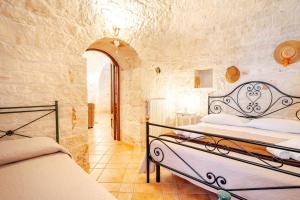 a bedroom with two beds in a stone wall at Trullo il Mulino in Locorotondo