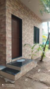 um edifício de tijolos com uma porta ao lado em आंगण होम स्टे em Malvan