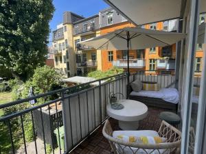 a balcony with a table and an umbrella at ApartmentInCopenhagen Apartment 1599 in Hellerup