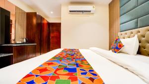 a bedroom with a bed with a colorful blanket at FabHotel Prime D2 in New Delhi