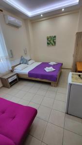 a room with two beds with purple sheets in it at Prinos Mare in Prinos