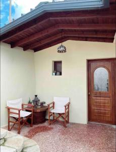 un patio con 2 sillas, una mesa y una puerta de madera en The Traditional Greek House, en Ioannina