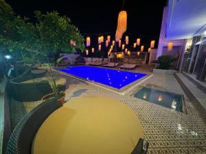una piscina en un patio por la noche en GÜLER BUTİK HOTEL, en Antalya