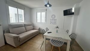 a living room with a couch and a table at Mirador Playa in Conil de la Frontera +7 photos