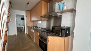 a kitchen with a stove and a microwave at Mirador Playa in Conil de la Frontera