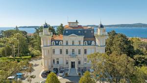 - une vue aérienne sur une grande maison blanche dans l'établissement Résidence les Tourelles, à Sainte-Maxime
