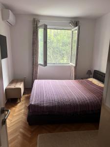 Un dormitorio con una cama grande y una ventana. en Apartment Lea, en Kotor