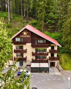 a large building with balconies and a parking lot at Boutique Hotel Casa Emil in Poiana Brasov