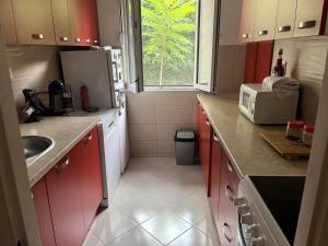 cocina con armarios rojos y nevera blanca en Apartment Lea, en Kotor