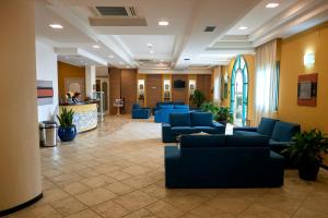 a waiting room with blue couches in a building at Baglio Dello Zingaro in Scopello