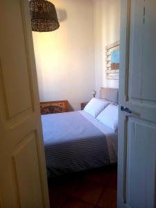 a bedroom with a bed with white sheets and a lamp at 99 Scalini in Naples