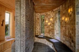 Zimmer mit einer Steinmauer mit 2 Bänken in der Unterkunft Permata Ayung Private Estate in Ubud