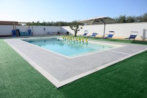 a swimming pool with a fountain in the grass at Villa La Gardenia in Marsala