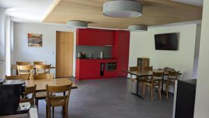 cocina con armarios rojos, mesa y sillas en BnB Fellacher, en Adelboden