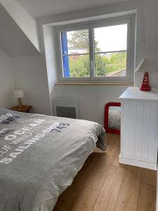 een slaapkamer met een bed en een raam bij Jolie petite maison proche mer in Le Pouliguen