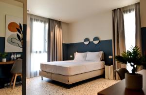 a bedroom with a large bed with a blue headboard at Rich Hotel Vlore in Vlorë