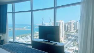 a flat screen tv sitting in front of a large window at Century Marina Hotel - Lusail in Lusail