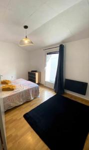 a bedroom with a bed and a window and a rug at Maison Saint Florent Le Vieil in Saint-Florent-le-Vieil +1 photo