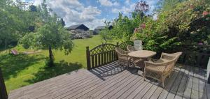 a wooden deck with a table and chairs on it at Ängdala Camping på Österlen in Kivik