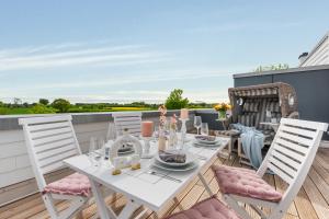 un tavolo da pranzo bianco e sedie sul balcone. di Ausguck 34 a Olpenitz Altre 25 foto