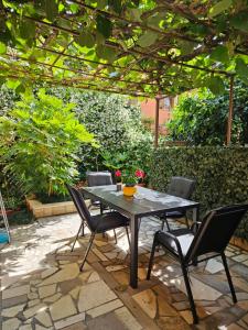 a table and chairs on a patio under a pergola at Apartman Bruna in Novigrad Istria