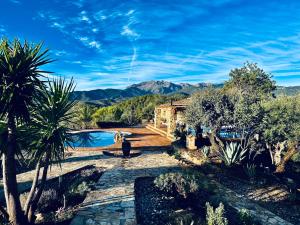 a house with a pool and mountains in the background at Poolhouse with private pool 360 degrees views over pure nature in Alozaina