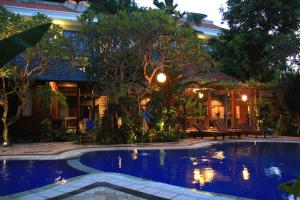 a house with a swimming pool in front of a house at Jepun Bali Hotel in Kuta