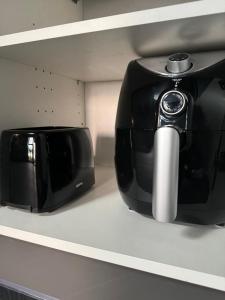 a black toaster sitting on a shelf next to a toaster at Eco House 1 in Prestatyn +15 photos