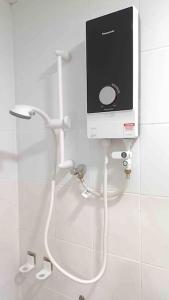 a bathroom with a shower with a monitor on the wall at Serdang Greenseeds Homestay 9-10pax MIECC in Seri Kembangan