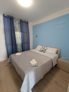 a bedroom with a large bed with towels on it at Maria Apartment in Vaccarizzo - Delfino