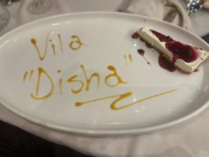 a piece of cake on a plate with a happy birthday at VILA DISHA in Tirana
