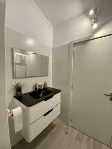 パタイアスにあるGoldBeach Houseの洗面台と鏡のある白いバスルーム