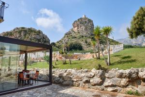 a house with a view of a stone wall at Baglio Dello Zingaro in Scopello
