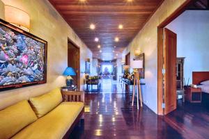 a living room with a couch and a painting on the wall at Sakura 4 BR Private Pool Villa JU27 in Ketewel