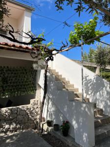 una scala per una casa bianca con scale e piante di Apartmani "Nikola" Seaview - Ivan Dolac, Hvar a Ivan Dolac