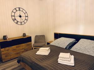 a bedroom with a bed and a dresser and a clock at Ferienwohnung am Schloßgarten in Oranienbaum-Wörlitz