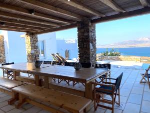 a wooden table and chairs on a patio with a view of the ocean at Villa Artemis in Agios Georgios