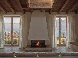 a living room with a fireplace with a view at Borgo SAN SONNEA Lake Garda in Torri del Benaco