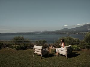 a woman sitting in a chair on the grass at Borgo SAN SONNEA Lake Garda in Torri del Benaco +19 photos